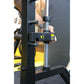 Black and yellow Smith machine with hand holding chrome linear bearing assembly during demonstration