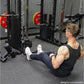 Man using black Smith machine with red weight plates in gym setting, weights not included