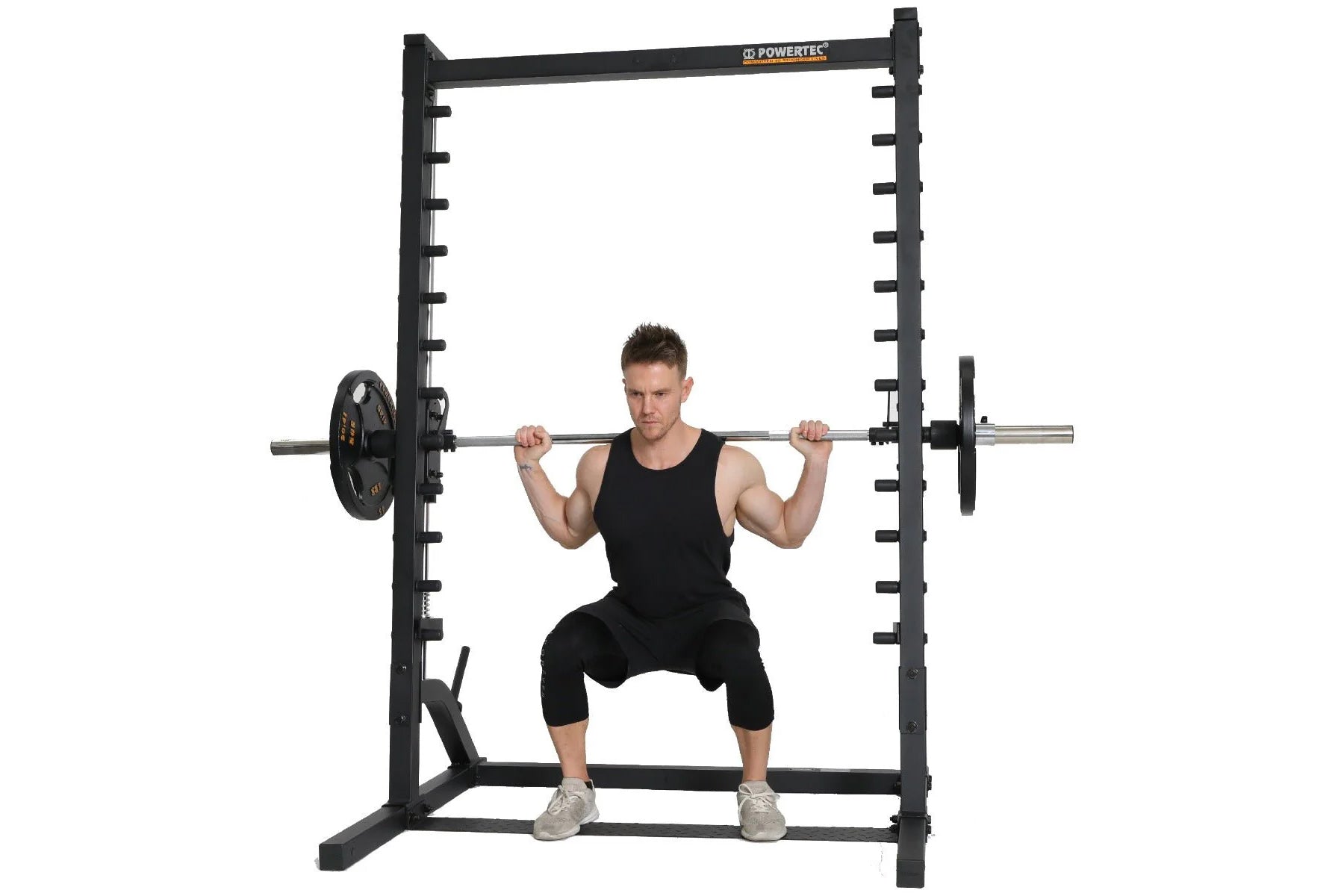 Black Powertec smith machine with loaded barbell, demonstrating squat exercise with model on white background