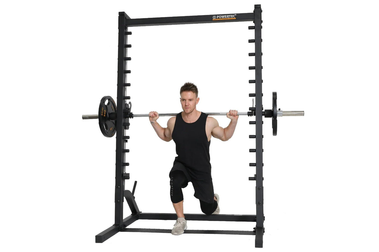 Black Powertec roller smith machine with male model performing squat exercise, chrome bar with weight plates on white backgro