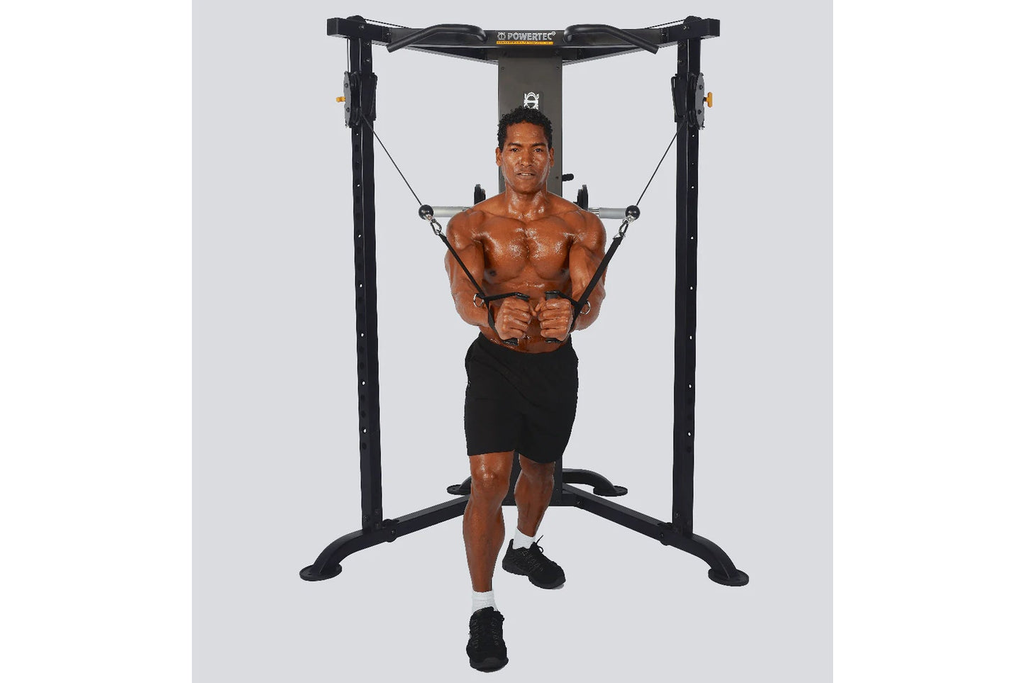 Powertec black functional trainer with dual cable stations, model demonstrated by shirtless man in black shorts performing ch