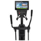 Black elliptical machine with digital touchscreen display console showing fitness content, dual moving handles, and pedal bas