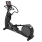 Black elliptical exercise machine with touchscreen console display and curved handles on white background