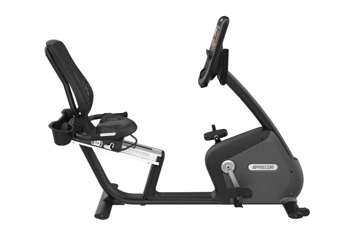 Black Precor recumbent exercise bike with padded seat, backrest, digital console, and foot pedals on white background