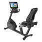 Black recumbent exercise bike with digital console displaying workout interface, featuring padded seat with backrest and foot