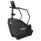 Black Precor stair climber with digital console, handrails, and foot pedals on white background