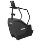 Black Precor stair climber with digital console, handlebar grips, and pedal platform on white background