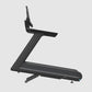 Black Precor treadmill with Z-shaped frame, wide running belt, and digital console mounted on angled upright, on white backgr