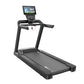 Black commercial treadmill with digital touchscreen console, dual handrails, and running belt on white background