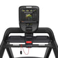 Black Precor TRM 531 treadmill with digital console displaying metrics, red emergency stop button, and attached headphone cor
