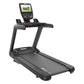 Black commercial treadmill with digital touchscreen console displaying fitness metrics and landscape video on white backgroun