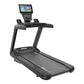 Black motorized treadmill with touchscreen display console, handrails, and red headphone cord on white background