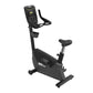 Black upright exercise bike with digital console display, padded seat, and stationary handlebars on white background