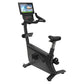Black upright exercise bike with touchscreen console displaying workout interface, padded seat and handlebars, on white backg