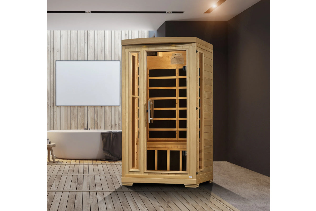 Natural wood infrared sauna cabin with glass door and black interior panels, displayed in modern bathroom setting
