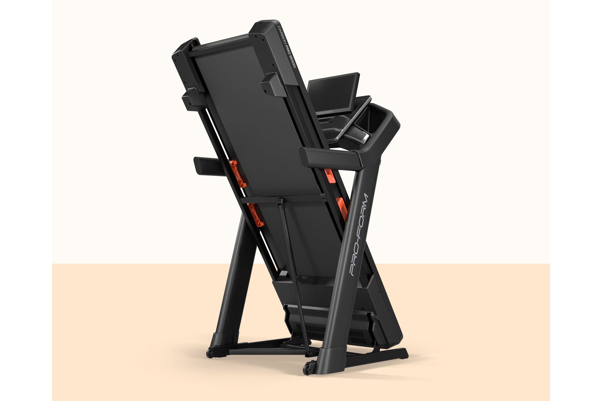 Black ProForm Carbon Pro 9000 motorized treadmill with red accents, digital console, and storage compartments, on beige backg