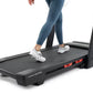 Woman running on black ProForm Carbon Pro 9000 treadmill wearing blue leggings and white sneakers