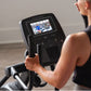 Pro-Form Plus Carbon E7 elliptical machine with touchscreen display, worn by model in black tank top