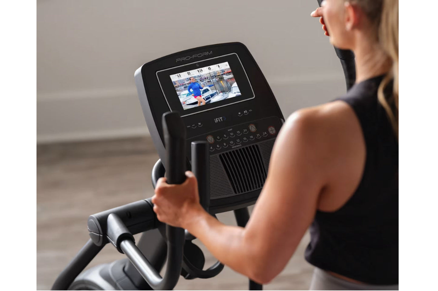Pro-Form Plus Carbon E7 elliptical machine with touchscreen display, worn by model in black tank top