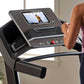 Black Proform treadmill with touchscreen display showing workout content, control buttons, and red emergency stop button, use