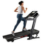 Woman running on black Proform Plus Trainer 1000 treadmill with digital display, wearing gray tank top and navy leggings