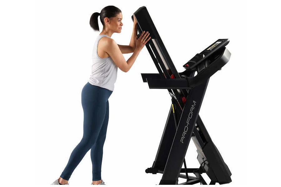 Woman using black Proform Plus Trainer 1000 treadmill with digital display, wearing white tank top and navy leggings