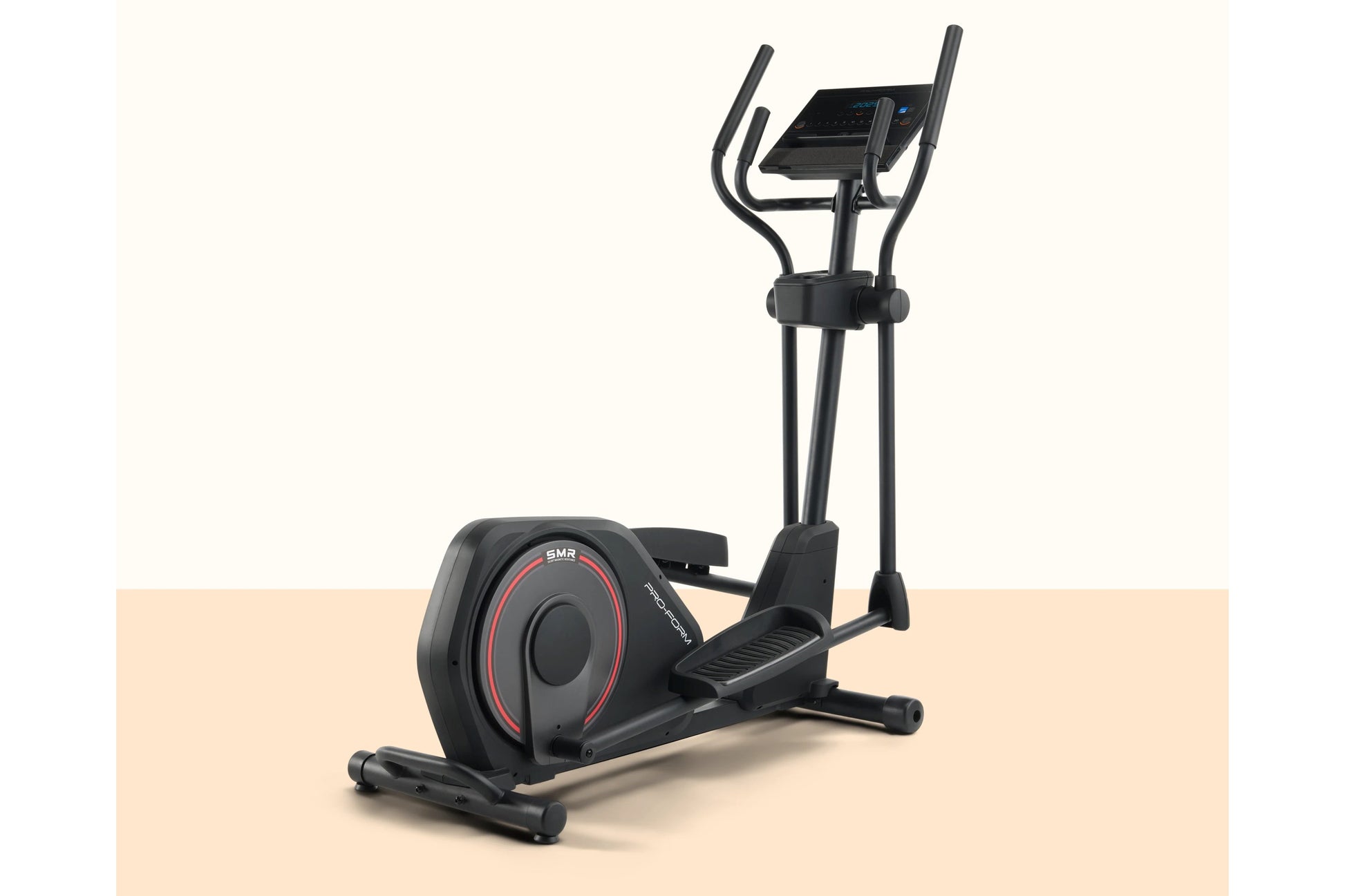 Black elliptical trainer with digital display console, dual handles, and red accent trim on wheel, shown on tan background