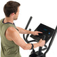 Man in olive tank top using black ProForm Sport Elliptical with digital console display, shown from side view