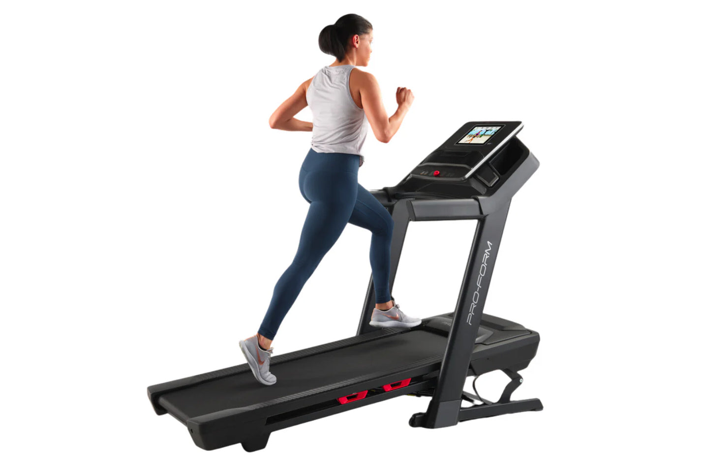 Woman running on black ProForm Trainer 1000 treadmill with touchscreen display, wearing gray tank top and navy leggings