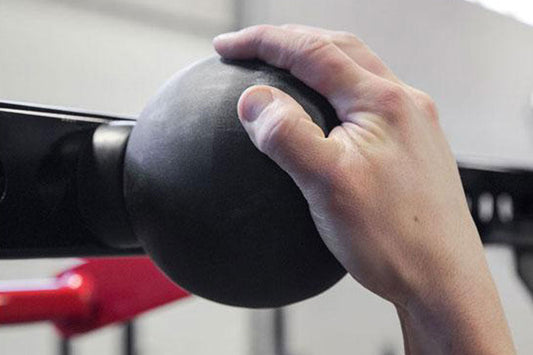 Hand holding black textured pull-up sphere grip training tool