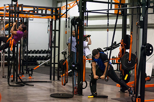 Purmotion FTS 200 Club Model Training Station with orange and black steel frame, multiple functional workout stations, and we