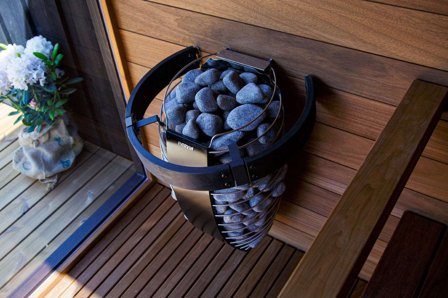 Black and blue safety railing with perforated design filled with blue stones, displayed on wooden deck
