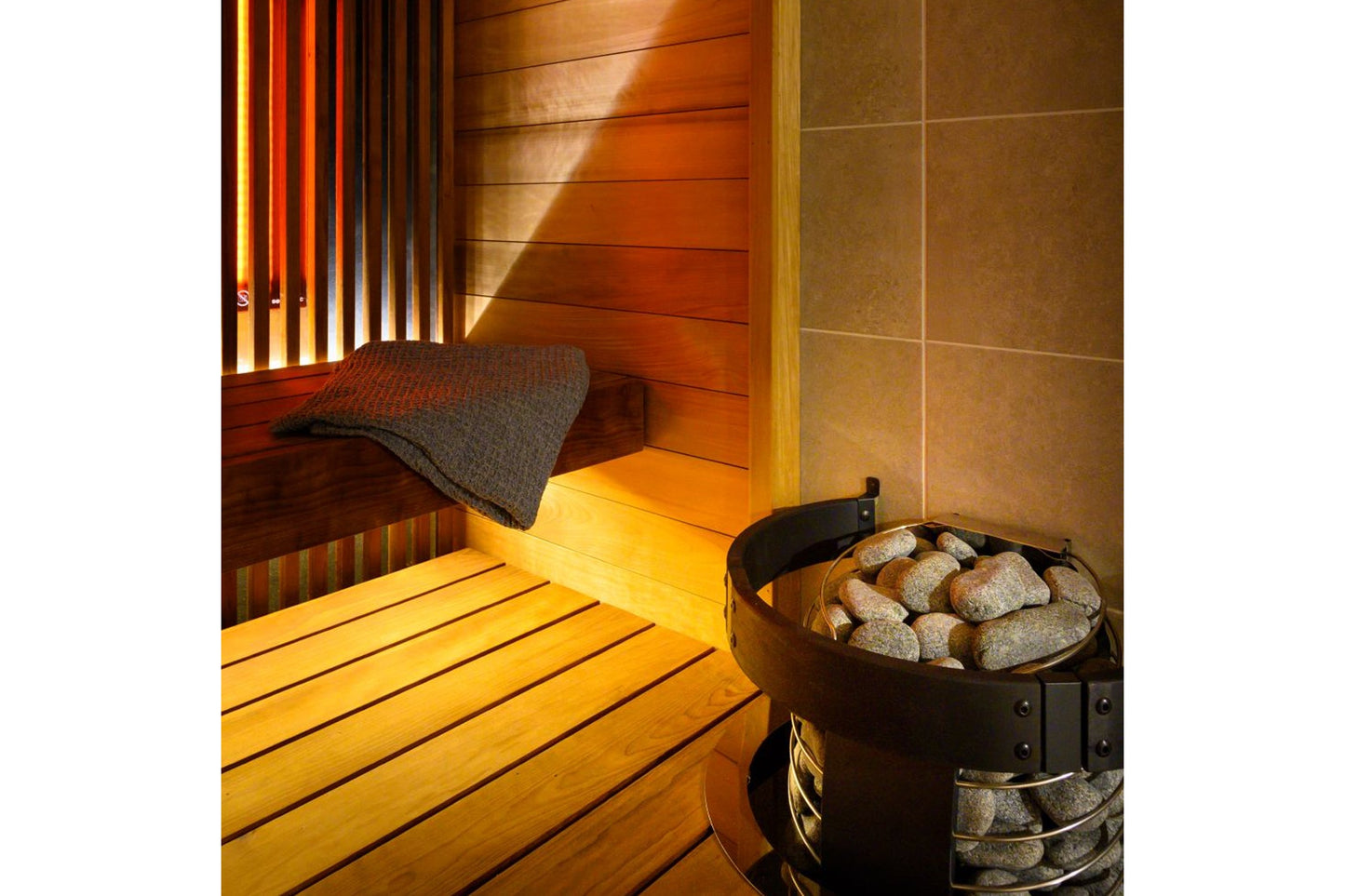 Harvia Spirit Safety Railing installed in wooden sauna interior with heated sauna stove and stones