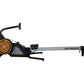 SHI-ROW Air rowing machine with orange and black design, gray beam, and digital monitor on white background