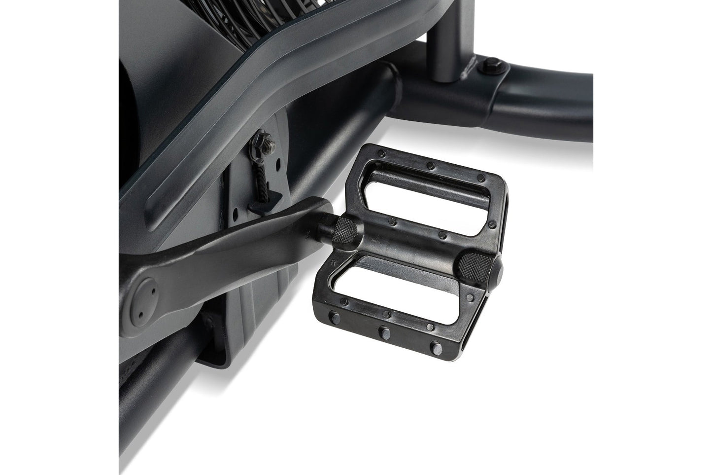 Black metal pedals with textured grip surface attached to exercise bike frame on white background
