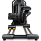 Black and gray elliptical machine with orange accents, dual handle bars, and footpads on white background