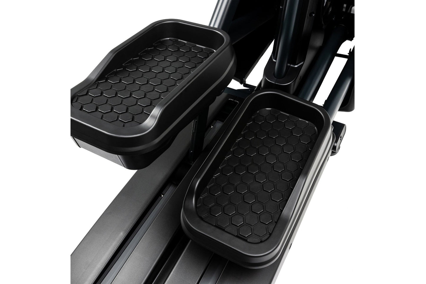 Black rubberized foot pedals with hexagonal textured pattern on Spirit CE900 elliptical machine, on white background