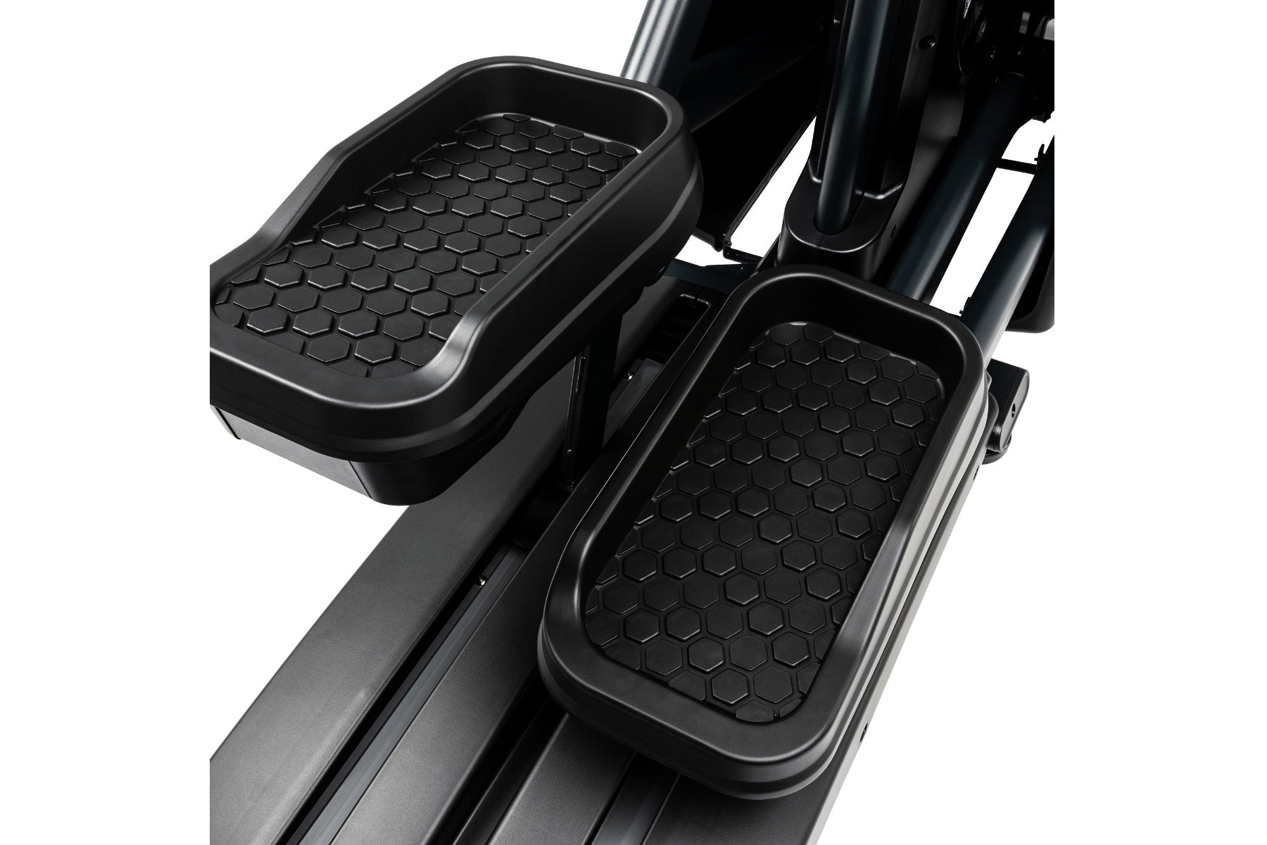 Black rubberized foot pedals with hexagonal textured pattern on Spirit CE900 elliptical machine, on white background