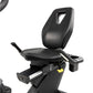 Black recumbent exercise bike with padded seat, backrest with handle cutout, armrests, and foot pedals on white background