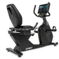 Black Spirit recumbent exercise bike with digital touchscreen console, padded seat, and foot pedals on white background