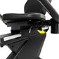 Black recumbent exercise bike with padded seat, foot pedals with yellow accent, and adjustable armrests on white background