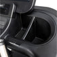 Black plastic cup holder and storage compartment on treadmill console, close-up detail view