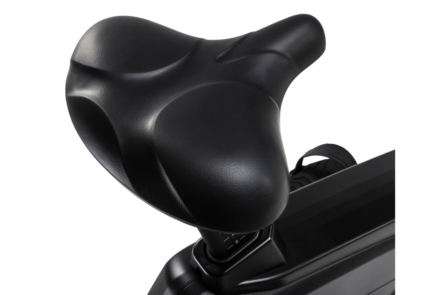 Black contoured seat with ergonomic design on stationary upright bike, close-up view