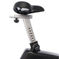 Stationary upright exercise bike with black padded seat, silver metal frame, adjustment dial, and white background