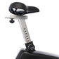 Upright exercise bike seat with black cushioning and silver metal post featuring adjustment knob, on white background