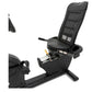 Black recumbent exercise bike with mesh-backed seat, digital console, and foot pedals on white background