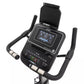 Spirit XBU55 upright exercise bike with black frame, digital display screen, padded seat, and curved handlebars on white back