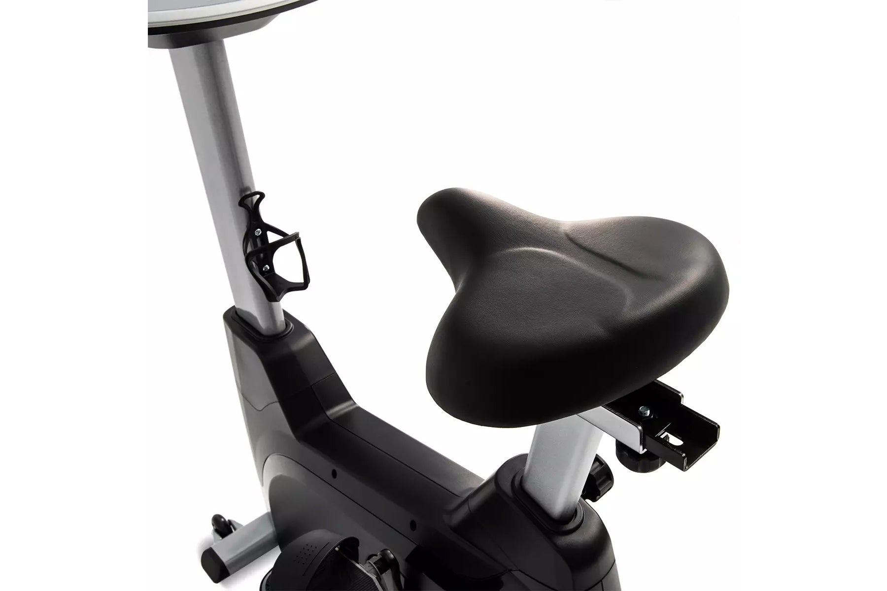 Upright exercise bike with gray frame, black seat, and pedals on white background