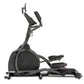 Black and gray Spirit XE395 elliptical trainer with foot pedals, padded seat, upright handles, and device holder on white bac