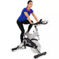 Woman in blue v-neck shirt with magenta trim and black leggings riding Spirit XIC600 stationary exercise bike on white backgr